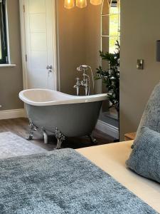 a bath tub in a bedroom with a bed at Kittys Haven in Castlemaine