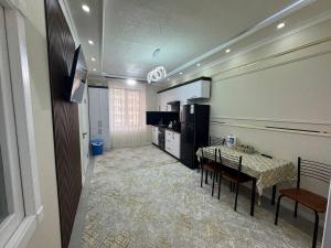 a kitchen and dining room with a table and chairs at Runa modern flat in Samarkand