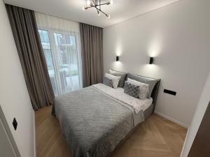 a bedroom with a bed and a large window at Pajūrio Namai in Palanga