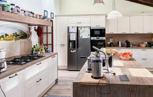 a kitchen with white cabinets and a stainless steel refrigerator at Can Taco in Galilea