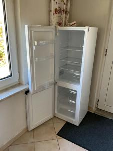 a white refrigerator with its door open next to a window at Haus Wünsche in Wieck
