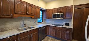 a kitchen with wooden cabinets and a sink and a microwave at Distinguished Home in Scranton