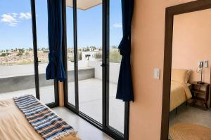 a bedroom with glass doors leading to a balcony at Simple Stay, Big Views, Private Room & Pool in Todos Santos +11 photos