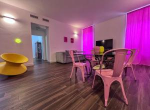 a dining room with a table and chairs and pink lights at Casa di in Ascoli Piceno
