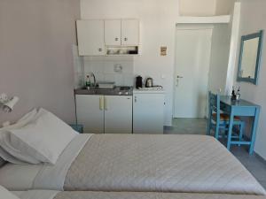 a bedroom with a bed and a small kitchen at Kamelia in Kokkari