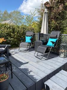 three chairs and an umbrella on a patio at Falconwood in Ifton Heath