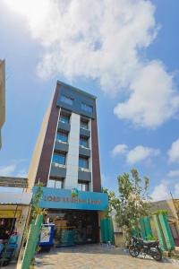 a tall building with a sign in front of it at Hotel Lord Krishna Dham in Dwarka