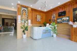 a lobby with wooden walls and a counter with plants at Hotel Lord Krishna Dham in Dwarka