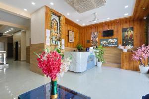 a lobby with a vase of flowers on a table at Hotel Lord Krishna Dham in Dwarka