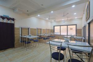 a conference room with tables and chairs and a stage at Hotel Lord Krishna Dham in Dwarka