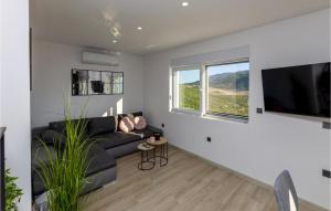 a living room with a black couch and a flat screen tv at Beautiful Home In Vrgorac in Vrgorac