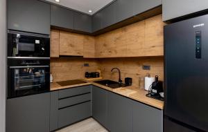 a kitchen with stainless steel appliances and wooden walls at Beautiful Home In Vrgorac in Vrgorac