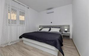 a white bedroom with a bed and a window at Beautiful Home In Vrgorac in Vrgorac