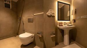 a bathroom with a toilet and a sink at Yashobhoomi Hotel Grand Tashree in New Delhi +26 photos