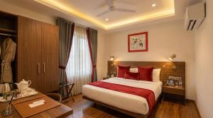a hotel room with a bed with red pillows at Yashobhoomi Hotel Grand Tashree in New Delhi