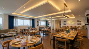 a dining room with wooden tables and chairs at Yashobhoomi Hotel Grand Tashree in New Delhi