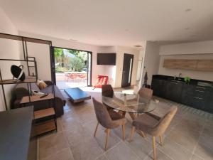 a living room with a glass table and chairs at Escapade à Saint-Saturnin-les-Avignon in Jonquerettes