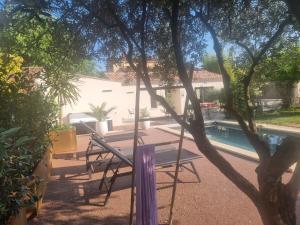 a table and chairs sitting next to a swimming pool at Escapade à Saint-Saturnin-les-Avignon in Jonquerettes