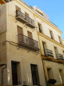 un gran edificio con balcones en un lateral en Alfaqueque Apartment, en Sevilla