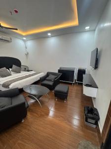 a bedroom with a bed and a tv and chairs at CNS Hotels in Ghaziabad +52 photos