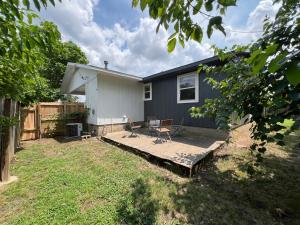 a backyard with a house with a wooden deck at Lion House in Bentonville