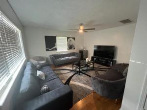 a living room with a couch and a television at Lion House in Bentonville