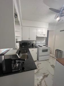 a kitchen with white cabinets and a stove top oven at Lion House in Bentonville