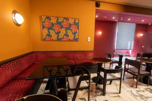 a restaurant with tables and chairs and a painting on the wall at Boutique Hotel Metro 900 in Naples