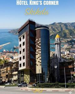 a building with a clock tower next to the ocean at Hôtel Corner King in Skikda