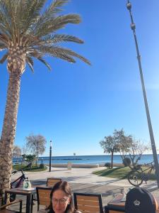 a woman sitting at a table in front of a palm tree at Casa Marítima in Altea