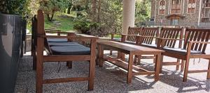 a wooden bench with two chairs and a table at Hotel Xalet Verdú in Arinsal