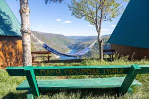 a green bench sitting on top of a hill with a hammock at Rural Resort Tron in Plužine +34 photos