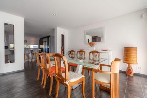 a dining room with a glass table and chairs at Marianas in Bom Sucesso