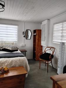 a bedroom with a bed and a chair and a table at Prosper Stud Guest House in Robertson
