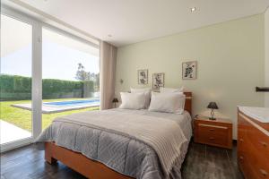 a bedroom with a bed and a large window at Marianas in Bom Sucesso
