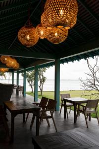 a patio with tables and chairs and a chandelier at Aayu Lagoon in Negombo