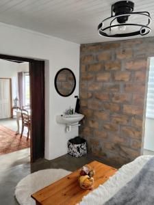 a living room with a brick wall and a table at Prosper Stud Guest House in Robertson +48 photos
