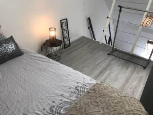 a bedroom with a bed and a table with a lamp at jolie studio 25 in Arras