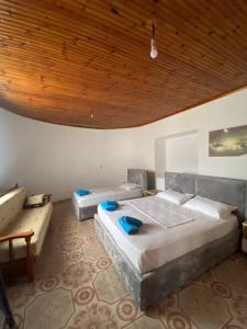 a bedroom with two beds and a wooden ceiling at Vila Demiraj Ksamil Sarande in Ksamil