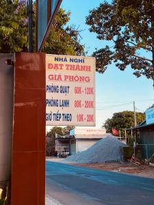 a sign on the side of a road next to a building at Nhà Nghỉ Đạt Thành in Giồng Tú Ðiền