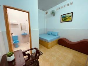a bathroom with a toilet and a bench in a room at Nhà Nghỉ Đạt Thành in Giồng Tú Ðiền