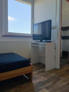 a room with a tv and a table with a bed at Noclegi Adam in Radonia