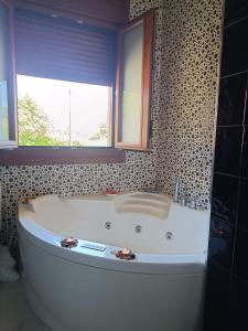 a large white tub in a bathroom with a window at Casa Agarimo in Arcade +9 photos