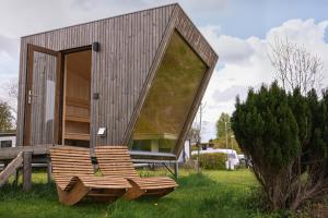a small house with a bench in front of it at Tiny House Nook 3 - Green&Tiny Hideaway Eider in Süderstapel