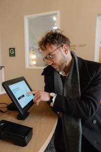 a man sitting at a table looking at a computer at The Drey - Kensington, Earl's Court in London
