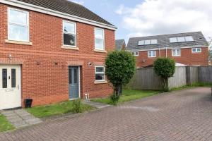 a brick house with a white door and a fence at Spacious 3BR Durham Home Contractor Friendly in Durham