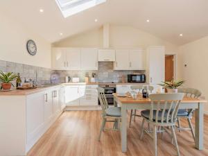 a kitchen with white cabinets and a table and chairs at 2 Bed in Winchester oc-77384 in Owslebury +7 photos