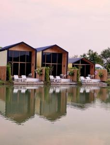 a building with tables and chairs in the water at Kiangnapa Cottage in Kanchanaburi City