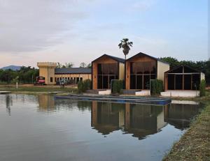 a building with a reflection in a body of water at Kiangnapa Cottage in Kanchanaburi City