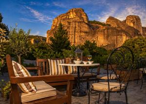 a table and chairs with a mountain in the background at Hotel Doupiani House in Kalabaka